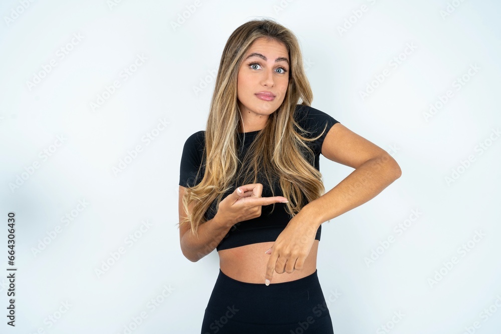 Φωτογραφία Young beautiful woman wearing sport clothes In hurry pointing to watch time, impatience, upset and angry for deadline delay