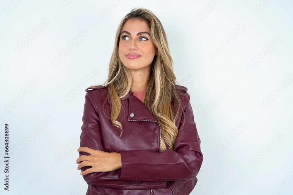 Pleased Beautiful young woman wearing jacket keeps hands crossed over chest looks happily aside Pleased Beautiful young woman wearing jacket keeps hands crossed over chest looks happily aside