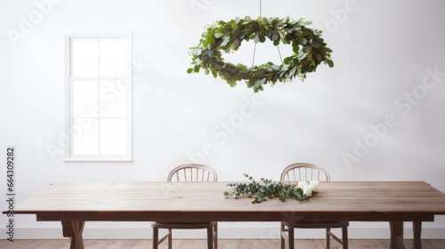 Christmas Scandinavian minimal decorations. Hanging evergreen wreath under wooden table at minimal modern white room. Modern and minimalist Christmas decor