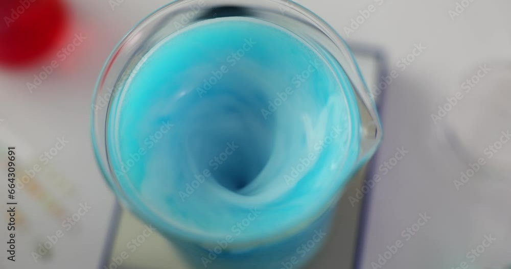 Laboratory chemical equipment and magnetic stirrer. Blue liquid is mixed in a glass. Laboratory chemical equipment and magnetic stirrer. Blue liquid is mixed in a glass.
