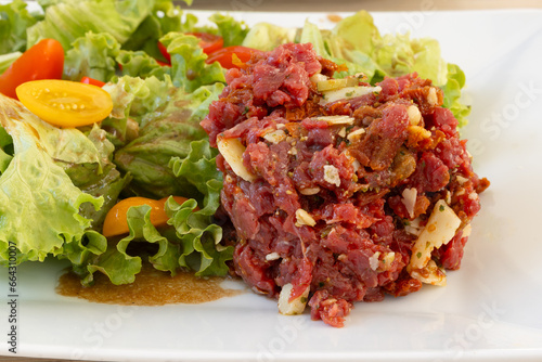 tartare de boeuf au parmesan et salade, en gros plan, dans une assiette