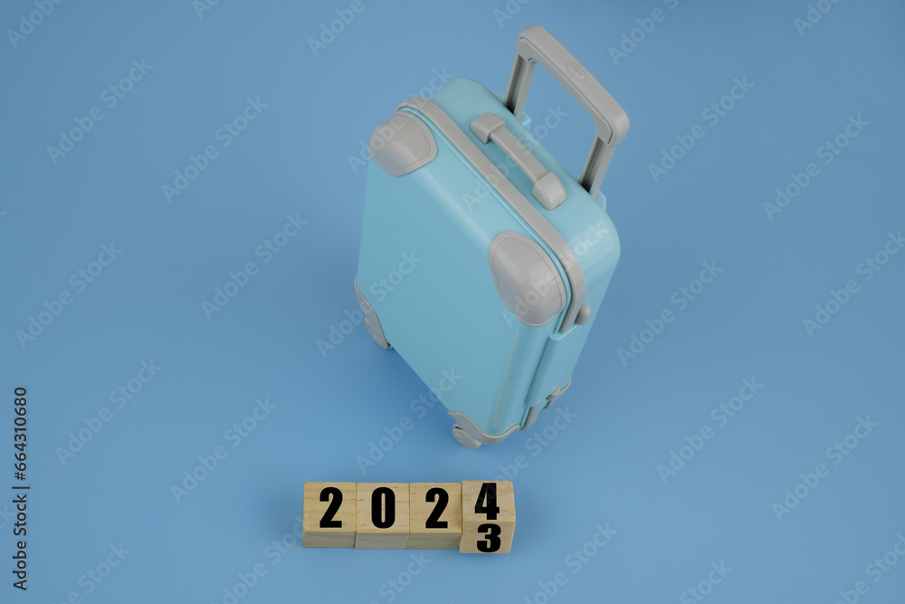 Suitcase and numbers 2023 and 2024 on blue background. Suitcase and numbers 2023 and 2024 on blue background.