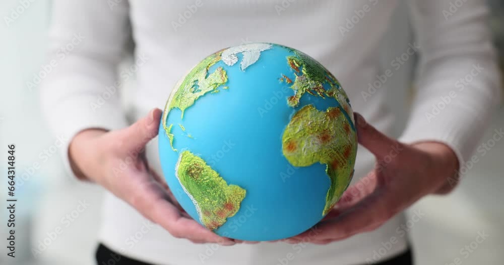Woman holds in hands globe with bright green continents. Human concern for well-being of planet Woman holds in hands globe with bright green continents. Human concern for well-being of planet