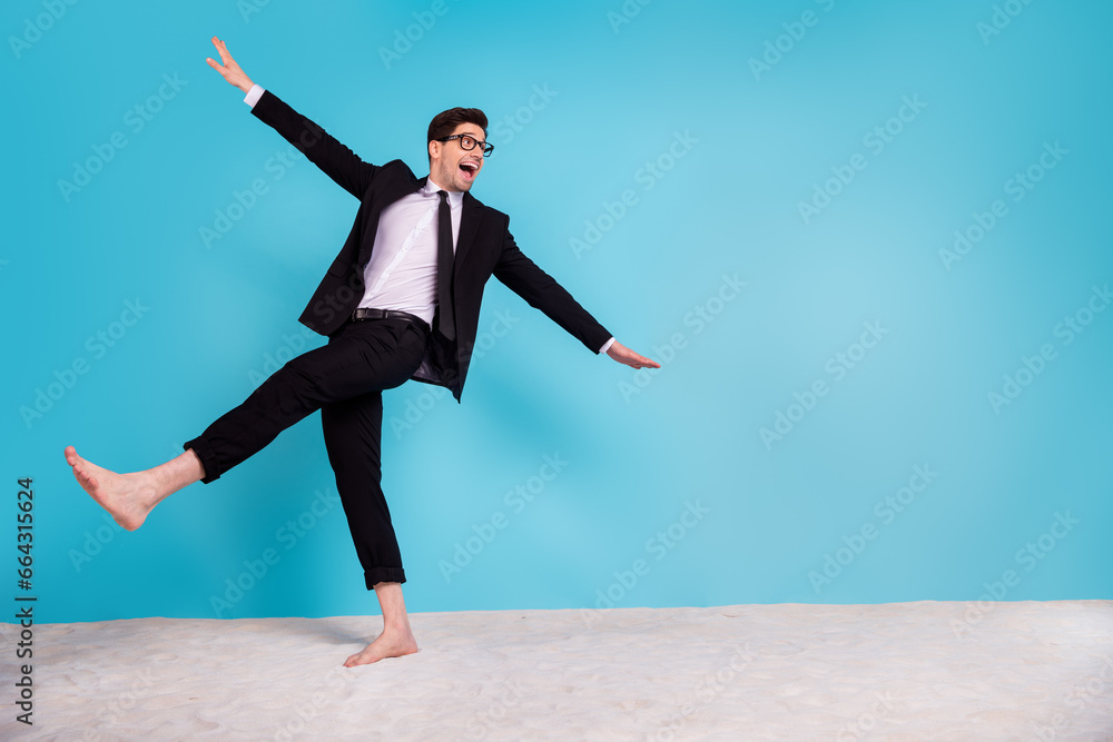 Full length photo of carefree positive guy dressed black tuxedo having fun beach empty space isolated blue color background