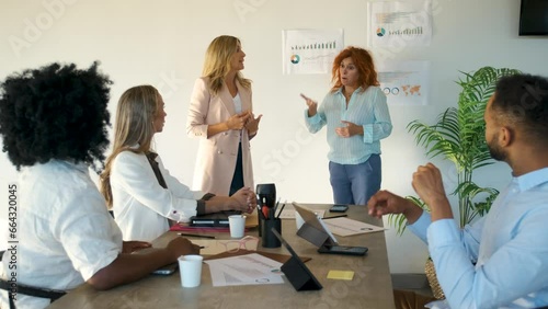 Company CEO talking with sign language translator for inclusion in a meeting at a coworking office.