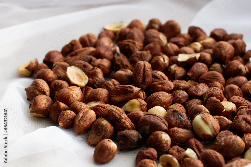 Fresh, young, unroasted hazelnuts or hazelnut kernels. Against the background of a delicate white curtain. Daylight. Natural color. Fresh, young, unroasted hazelnuts or hazelnut kernels. Against the background of a delicate white curtain. Daylight. Natural color.