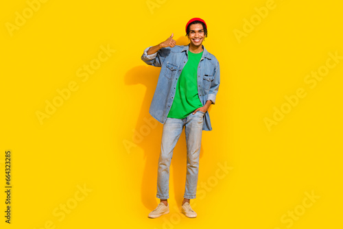 Full size photo of nice young guy showing thumb up shopping banner wear trendy jeans outfit isolated on yellow color background