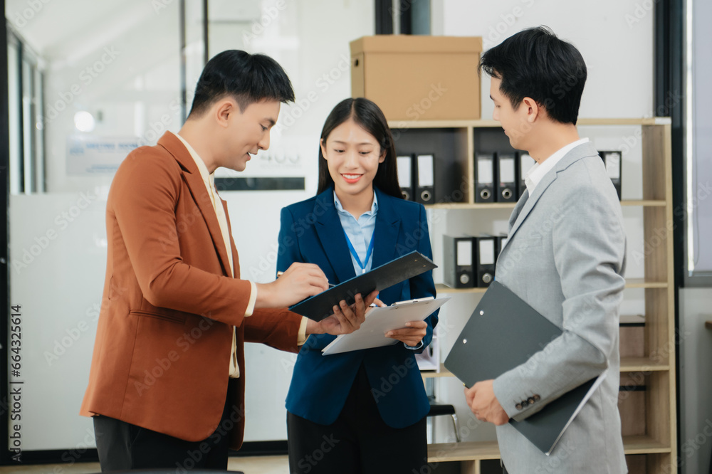Fototapeta premium Mid age Asian business woman ceo executive manager showing to colleagues team income revenue data figures planning on big screen in modern office.