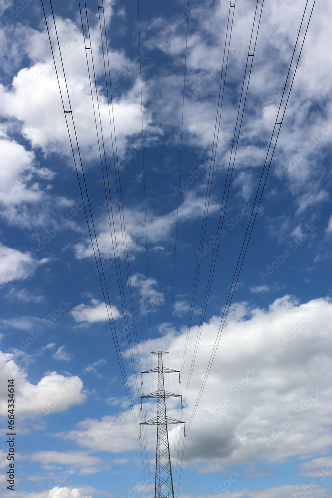 Masten einer Überlandleitung vor leicht bewölktem Himmel Masten einer Überlandleitung vor leicht bewölktem Himmel