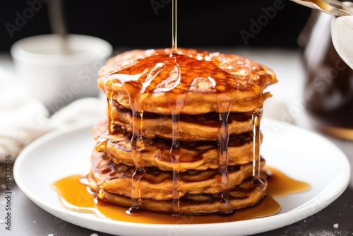 vegan sweet potato pancakes with maple syrup dripping down the side © altitudevisual