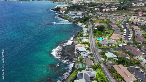 Aerial ocean coastal hotel resorts Kona Hawaii fast. Big Island. Luxury resorts, townhouses and homes on coast tropical landscape. Volcanic lava  environment. Economy is tourism based. Beach. photo