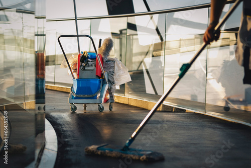 Reinigungskraft mit Arbeitsmitteln putzt