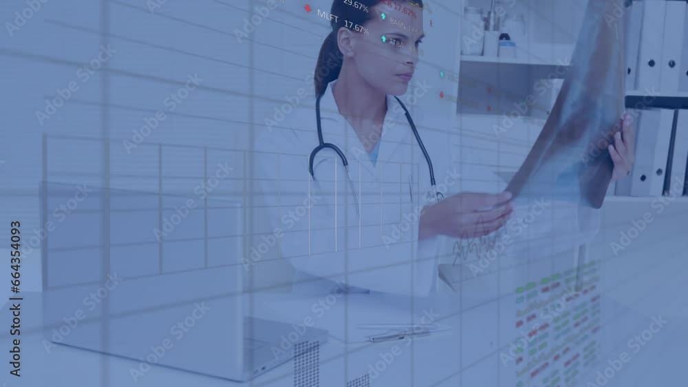Animation of stock market data processing over biracial female doctor checking reports at hospital Animation of stock market data processing over biracial female doctor checking reports at hospital