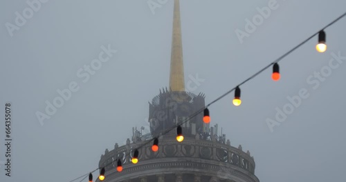 City tower in a fog, winter Christmas decorations on a strret photo