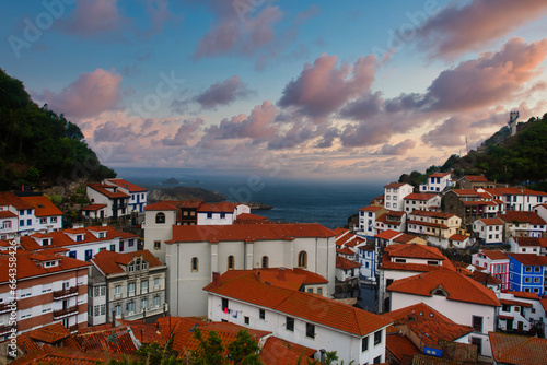 A panoramic view of the colorful clay-tiled houses of Cudillero with the Cantabrian Sea in the background photo