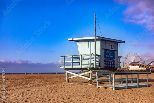Beautiful photograph of a lifeguard hut with the Santa Monica Pier amusement park in the background and over the Pacific Ocean, on the west coast of California in the United States of America. © Lifes_Sunday