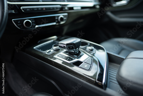 Gear shift on centre console between driver's and passenger seats of expensive vehicle. Lever of manual transmission in elegant design © port-o