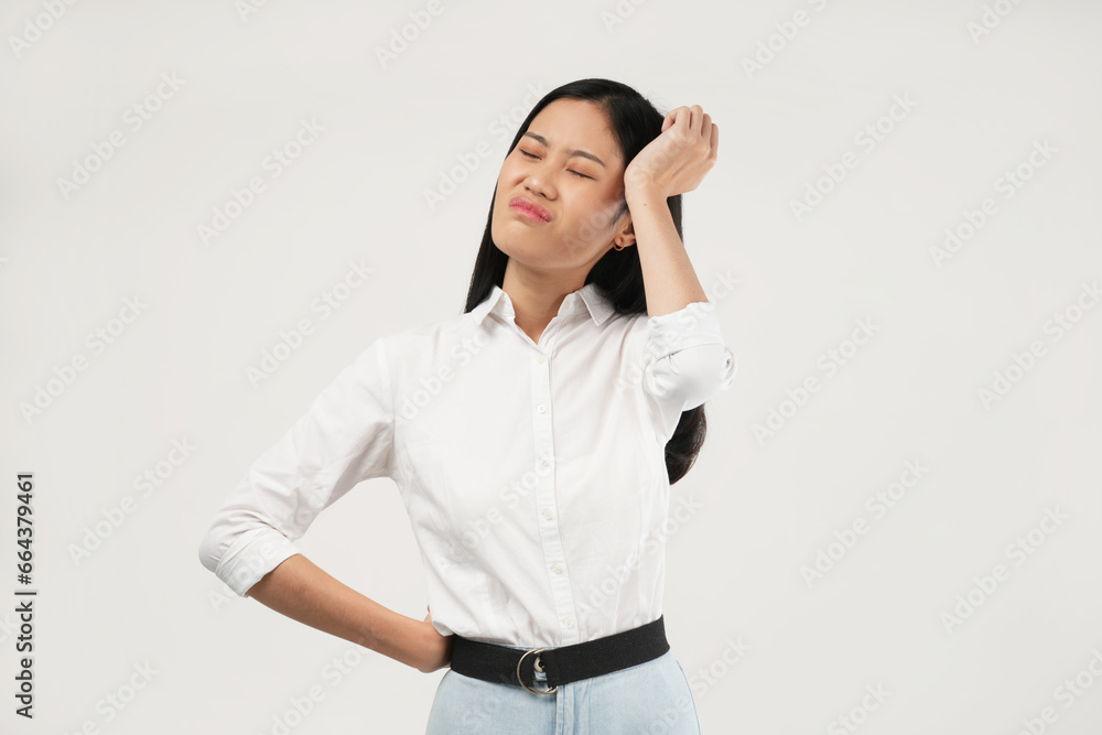The photo of a young Asian woman feeling unhappy and stressed touching her face, frowning. Indoor studio concept isolated on a white background. The photo of a young Asian woman feeling unhappy and stressed touching her face, frowning. Indoor studio concept isolated on a white background.