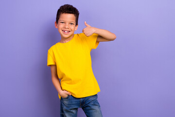 Photo of positive nice boy wear yellow trendy clothes thumb up cool feedback nice quality isolated on purple color background