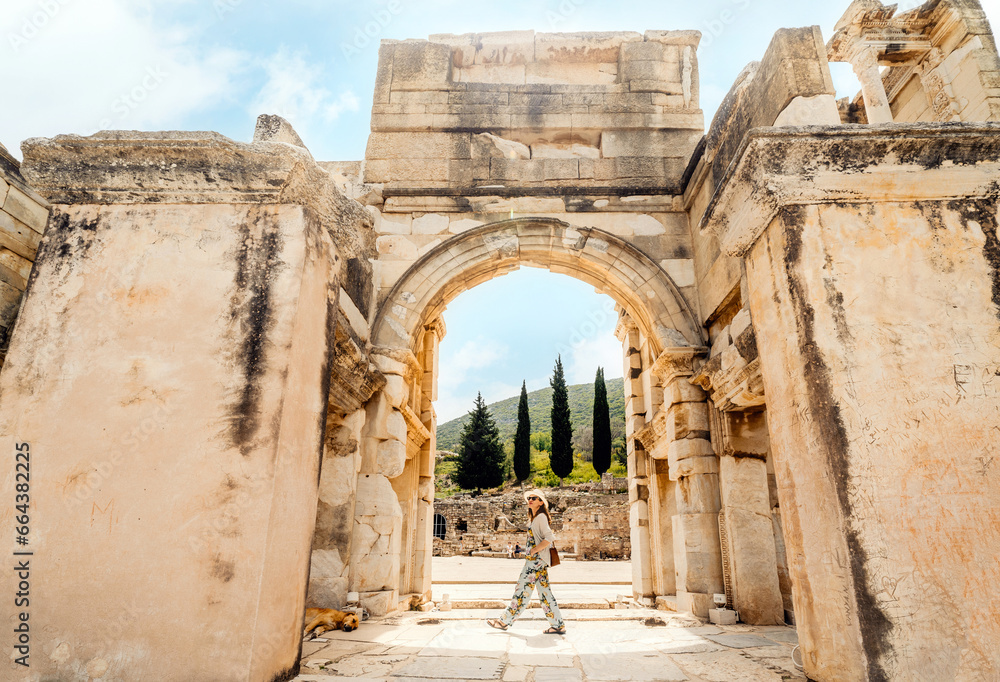 Tourist (woman) in the ancient city of Ephesus in Turkey with historic ruins in the background. Tourist (woman) in the ancient city of Ephesus in Turkey with historic ruins in the background.