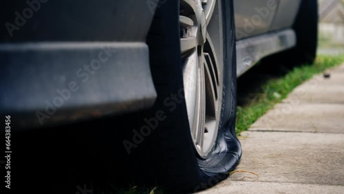 Car with flat tire on pavement