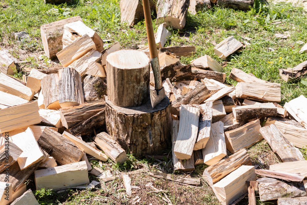stack of firewood in forest, lumberjack and the axe 