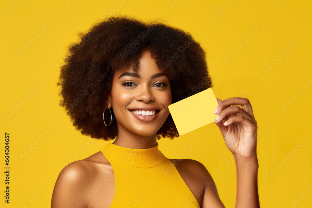 Winking woman holding credit card with hand isolated on yellow colored background. AI Generative - obrazy, fototapety, plakaty 