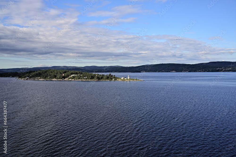 Wide angle view of the Oslofjord with forests and mountain landscape on the coast, with Sondre Langara Fog bell on Langara island, Norway