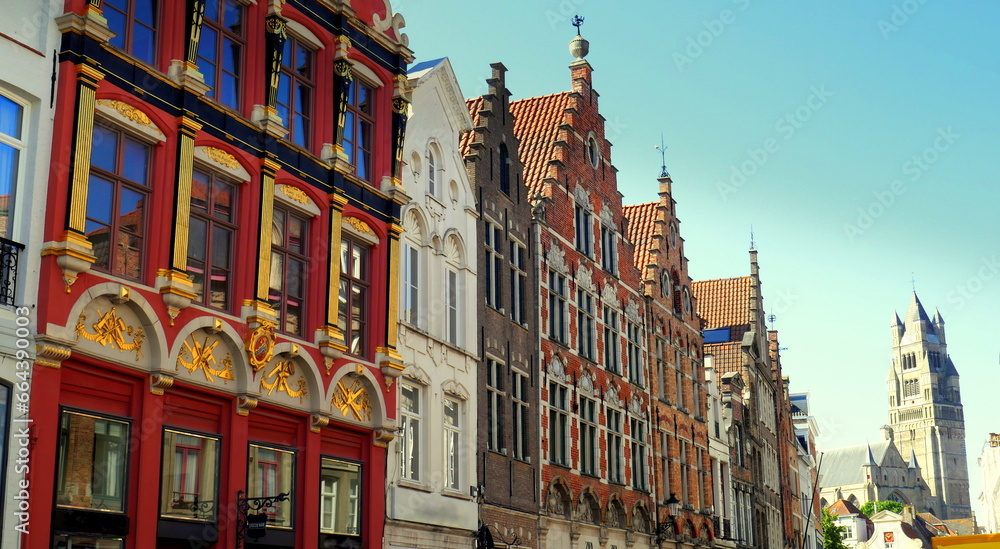 Obraz premium elegante Einkaufsstraße in Brügge mit mittelalterlichen Hausfassaden unter blauem Himmel