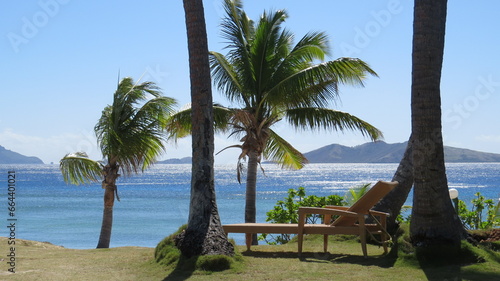 Wicker sunbed. Lounger in front of palmtrees and sea. Mana island  Fiji