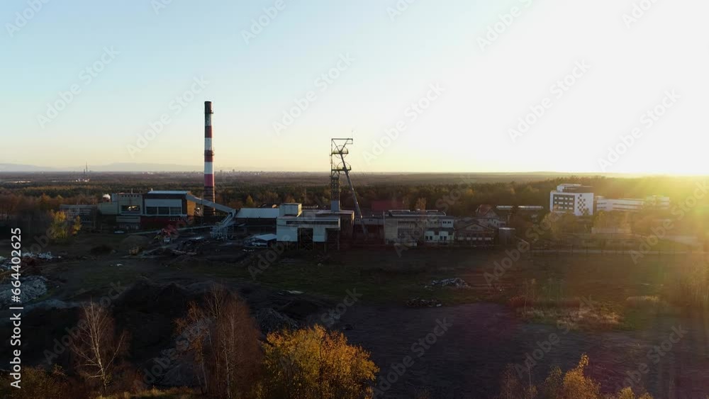 Mine shaft and industrial chimney. Coal mine elevator aerial cinematic view. Coal heaps and coal mine at sunset. Mine shaft silhouette view. Fossil fuel and minerals mining heavy industry Mine shaft and industrial chimney. Coal mine elevator aerial cinematic view. Coal heaps and coal mine at sunset. Mine shaft silhouette view. Fossil fuel and minerals mining heavy industry