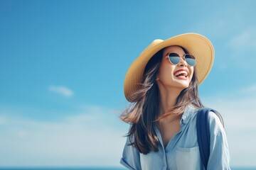 Happy young Asian tourist woman wearing beach hat, sunglasses and backpacks going to travel on holidays on blue background.
