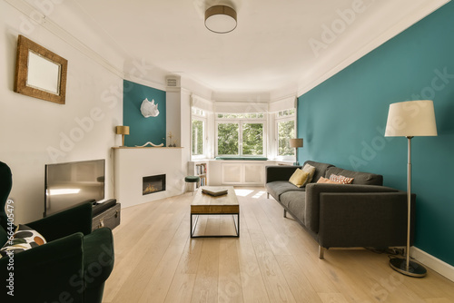 a living room with teal blue walls and white trim on the walls  hardwood flooring is light wood