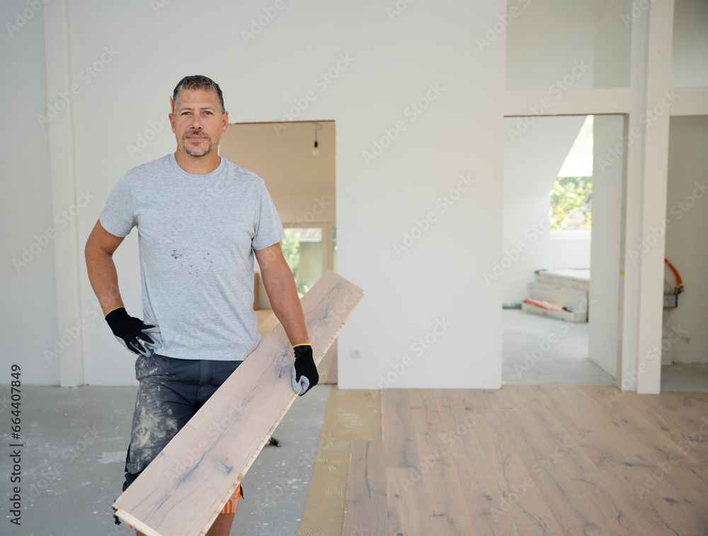 middle-aged man with gray hair glued, laying parquet floor in my loft apartment, top floor middle-aged man with gray hair glued, laying parquet floor in my loft apartment, top floor