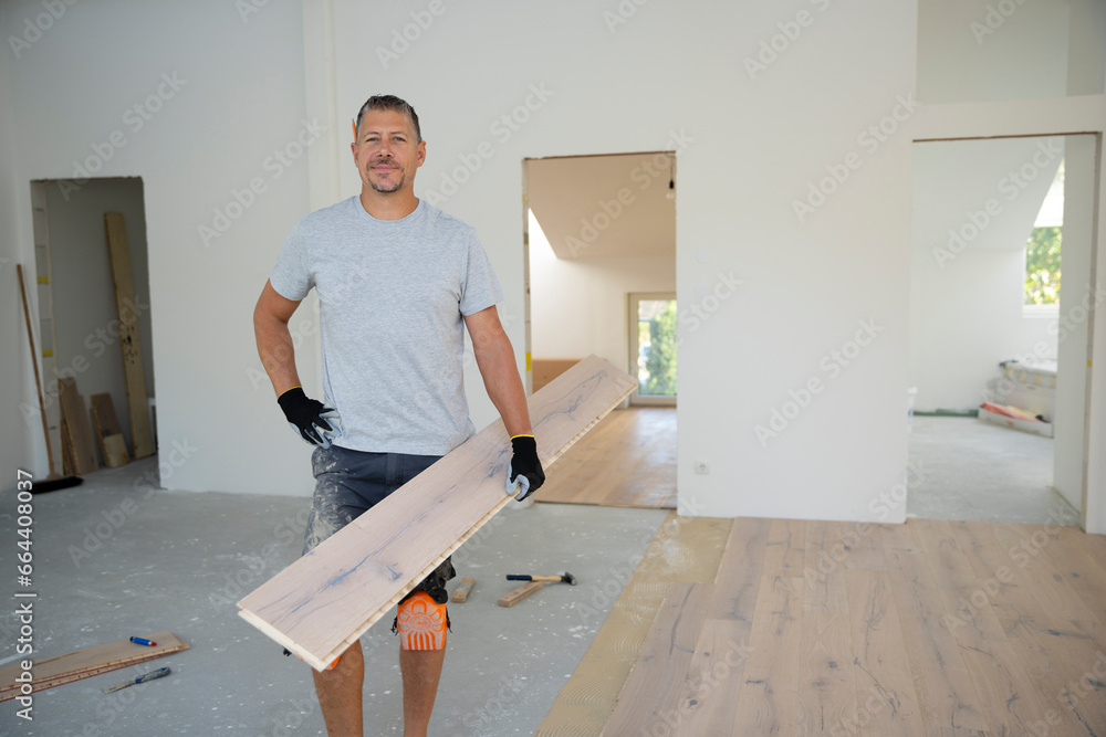middle-aged man with gray hair glued, laying parquet floor in my loft apartment, top floor middle-aged man with gray hair glued, laying parquet floor in my loft apartment, top floor