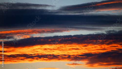 Textured background of beautiful sunset. Beautiful background blur. Amazing red and yellow sunset with "burning clouds" Panoramic sunset cloudscape dramatic sky. Sunset with light reflecting in clouds © Elena