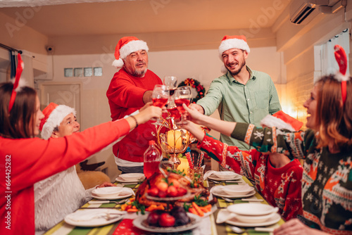 Group of happy family smiling happy celebrating christmas toasting with wine. Family member enjoy home made turkry grill dining togather at home. Christmas and New Year interior concept. photo