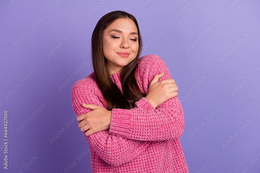 Obraz premium Portrait of adorable girl closed eyes hug shoulders silky clothes isolated on purple color background