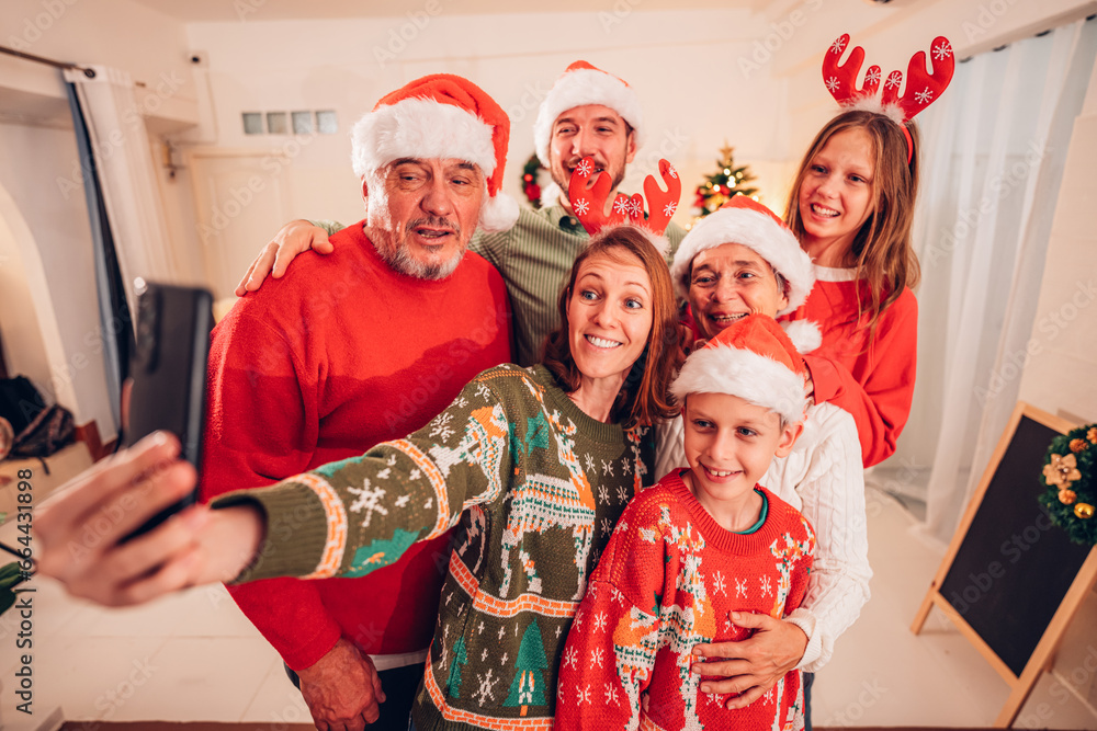 Fototapeta premium Merry Christmas and Happy Holidays, Cheerful grandparents grandchildren sister brother, son daughter taking self photo, photographing on mobile cell cellphone phone.