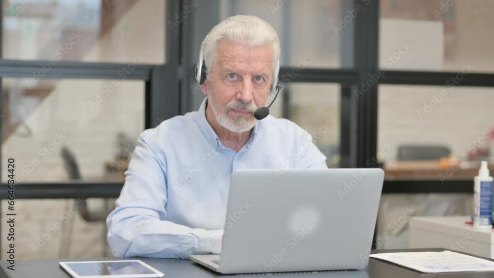 Old Man with Headset Looking at Camera in Call Center