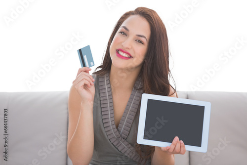 Digital png photo of happy caucasian woman with tablet and credit card on transparent background
