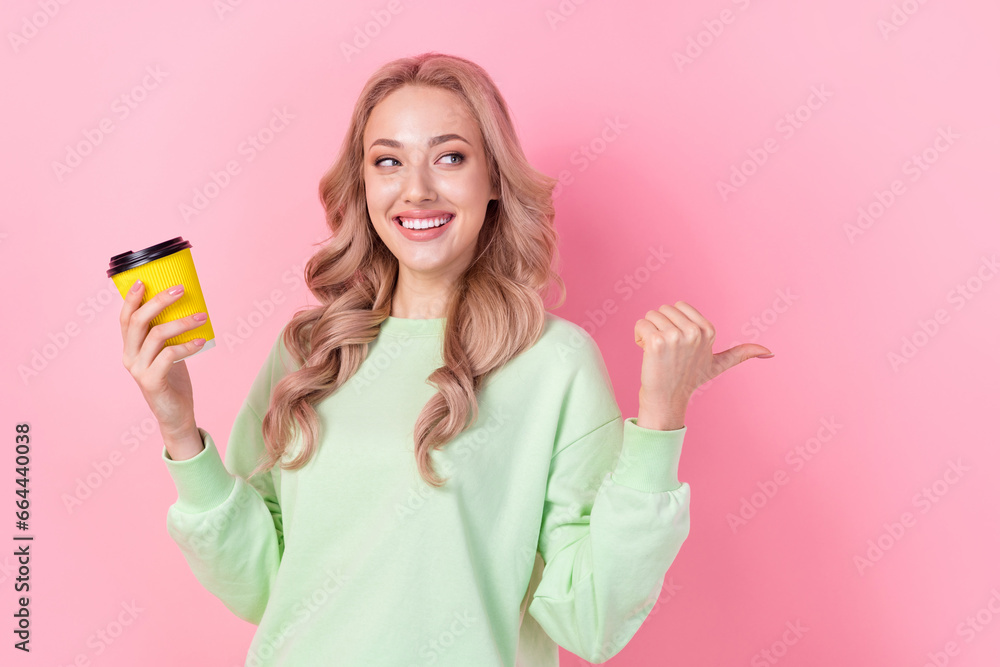 Portrait of lovely person hold coffee cup look indicate thumb finger empty space ad isolated on pink color background Portrait of lovely person hold coffee cup look indicate thumb finger empty space ad isolated on pink color background