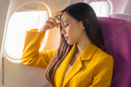 Fotografie Young asian chinese airplane passenger woman experiencing discomfort, Airplane headache