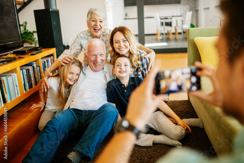 Konstfotografi Happy multigenerational family getting their picture taken in the living room