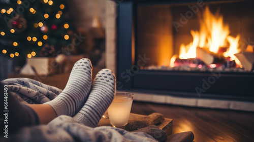 Cozy Winter Retreat: Point of View of Warm Feet Covered with Knit Socks Relaxing by the Fireplace in a Cabin