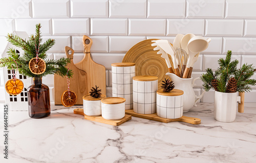 Beautiful New Year kitchen background with a set of kitchen utensils and jars for storing food, decorated with Christmas branches with natural decor. photo
