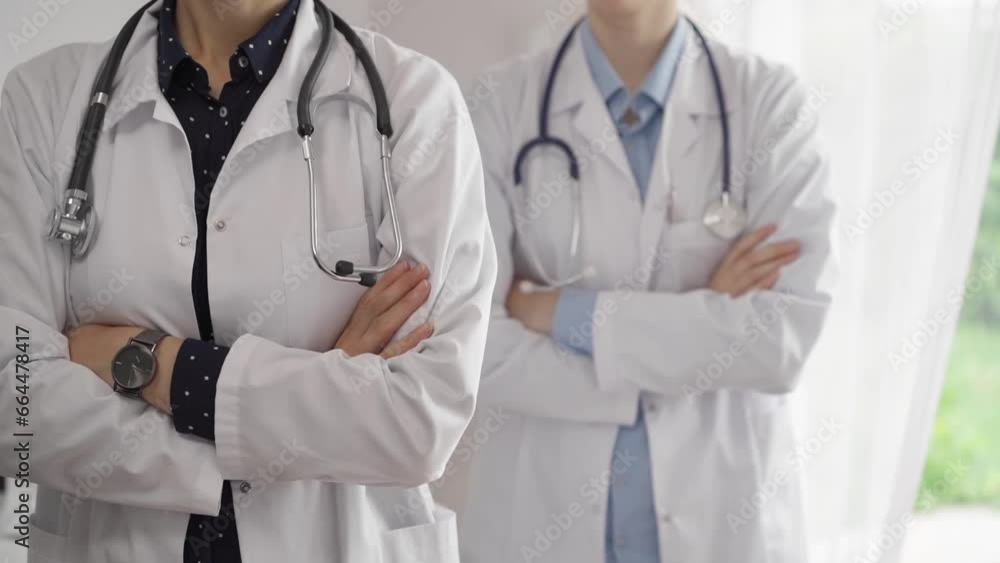 Doctor use the clipboard for making medication notes while another physician works in the background. Medicine concept Doctor use the clipboard for making medication notes while another physician works in the background. Medicine concept