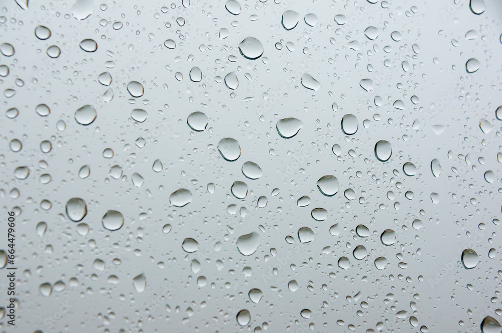Liquid purity: the delicacy of droplets on white glass.