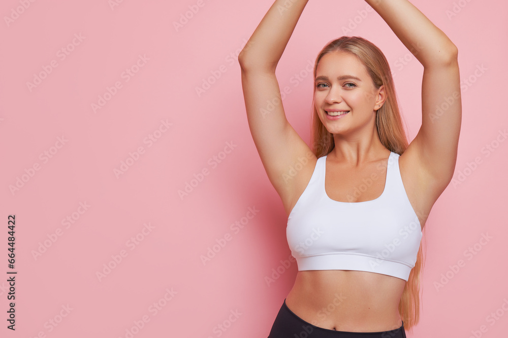 Beautiful smiling girl with fair hair standing against pink background with hands up, wonderful life concept, copy space Beautiful smiling girl with fair hair standing against pink background with hands up, wonderful life concept, copy space