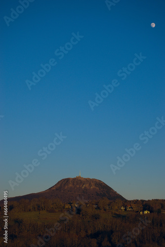 Volcano le Puy-de-dome on an evening of full moon and blue sky, Auvergne, France photo